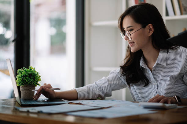 Accounting businesswomen are calculating income-expenditure and analyzing real estate investment data, Dedicated to the progress and growth of the company, Financial and tax systems concept stock photo