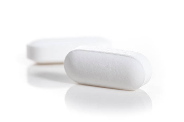 acetaminophen white oblong pain relief pills closeup with copyspace - pijnstiller stockfoto's en -beelden