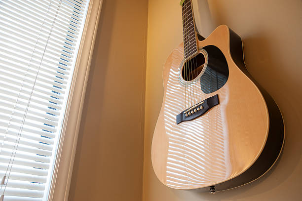 Acoustic guitar hanging on the wall close up stock photo
