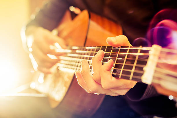 acoustic guitar the young guy playing an acoustic guitar. Shooting backlit guitar stock pictures, royalty-free photos & images