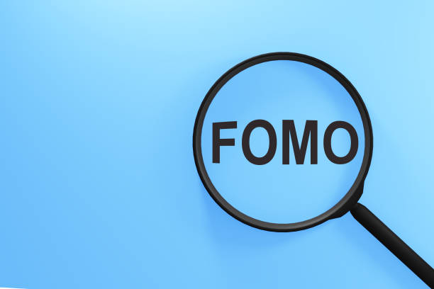 FOMO acronym, Fear of Missing Out on magnifier isolated on blue background FOMO acronym, Fear of Missing Out on magnifier isolated on blue background fomo stock pictures, royalty-free photos & images