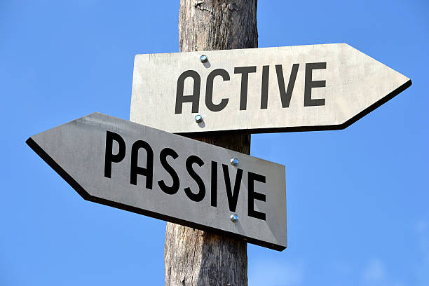 Active and passive signpost Wooden signpost with two arrows and black words on them. serene people stock pictures, royalty-free photos & images