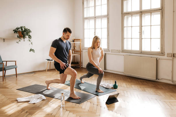 Active couple lunging in their spacious living room stock photo