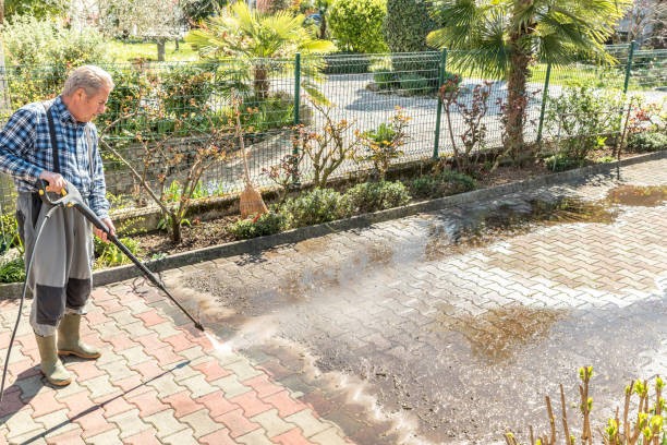 Active Senior Man Using High Pressure Washer to Clean the Entrance stock photo