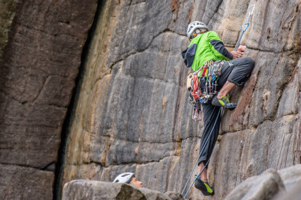 Active senior performing rock climbing activity. stock photo
