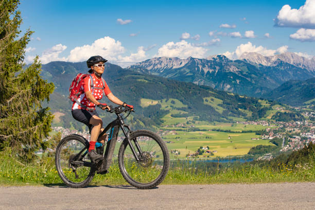 active senior woman on electric mountain bike pretty senior woman riding her electric mountain bike on the mountains above the Iller valley between Sonthofen and Oberstdorf, Allgau Alps, Bavaria Germany allgau alps stock pictures, royalty-free photos & images