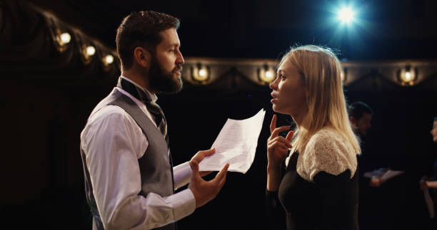 Actors rehearsing in a theater Medium shot of actors rehearsing in a theater while reading their scripts young male actors stock pictures, royalty-free photos & images