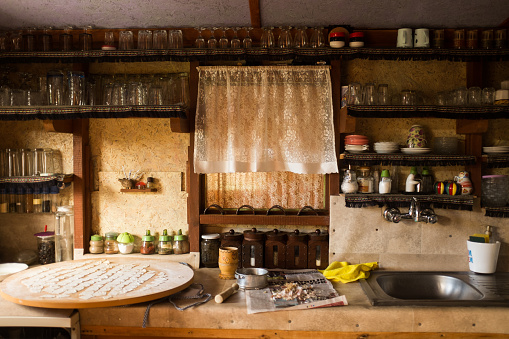 Actual rustic kitchen with utensils for cooking. Table at the foreground with copy space