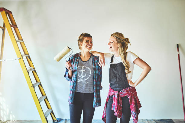 Adding a touch of beauty to their home Shot of two young woman busy with renovations at home roommate stock pictures, royalty-free photos & images