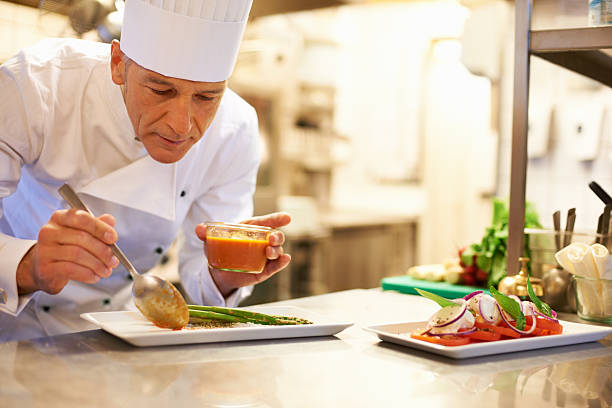 Adding the garnish to a lovely meal Portrait of a handsome chef adding the garnish onto a mouth-watering meal garnish stock pictures, royalty-free photos & images