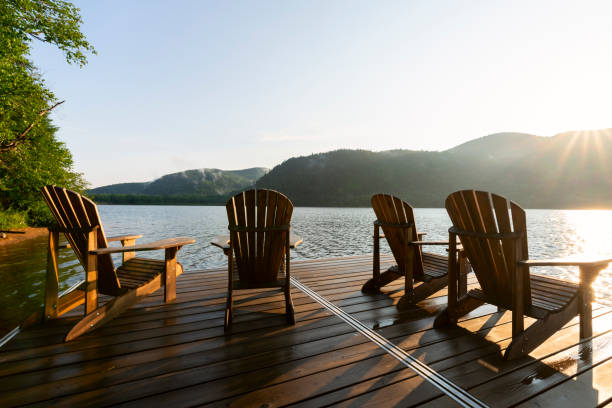 Adirondack deck chairs on lake dock stock photo
