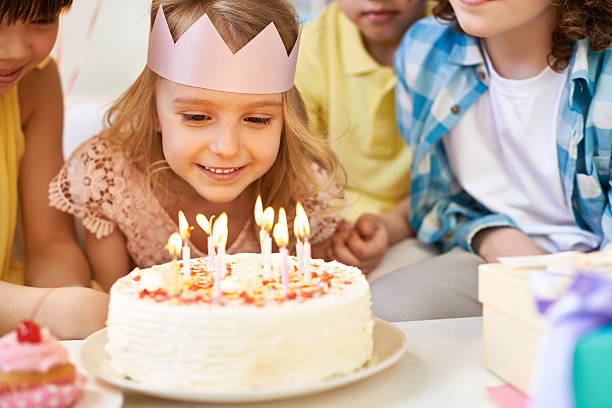 Admiring birthday candles Lovely little girl and her friends looking at burning birthday candles birthday candle stock pictures, royalty-free photos & images