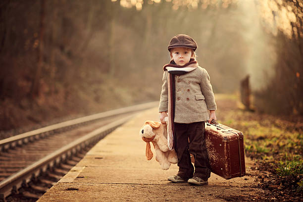 adorable boy on a railway station, waiting for the train - teddy ray stok fotoğraflar ve resimler