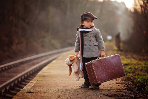 çok güzel çocuk bavul ve oyuncak ayı ile tren bekleyen bir tren istasyonu - teddy ray stok fotoğraflar ve resimler
