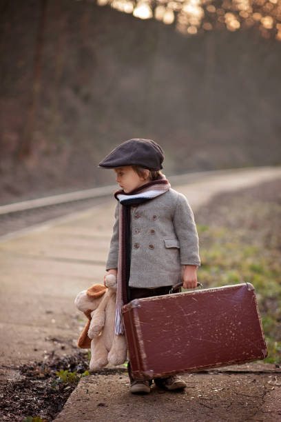 çok güzel çocuk bavul ve oyuncak ayı ile tren bekleyen bir tren istasyonu - teddy ray stok fotoğraflar ve resimler