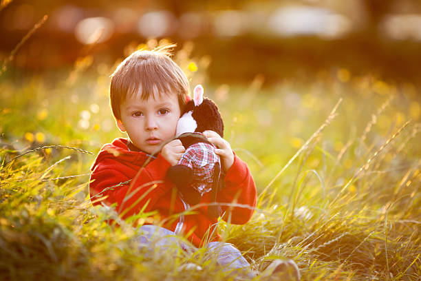 사랑스러운 남자아이 그의 테디 친구야, 앉아 잔디 - teddy ray 뉴스 사진 이미지