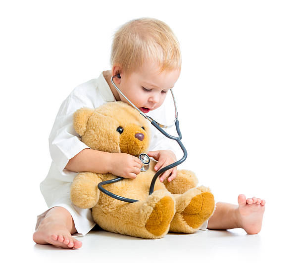 Adorable child with clothes of doctor and teddy bear toy stock photo