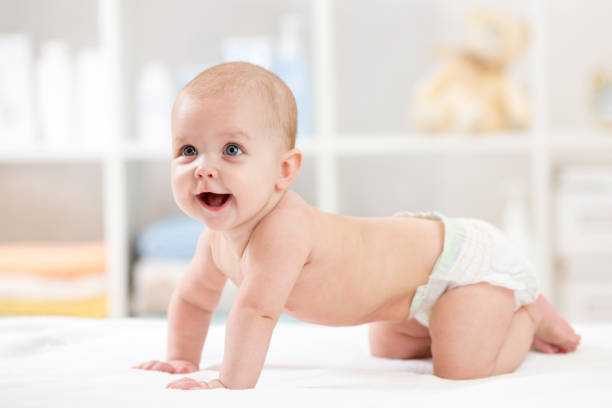 Adorable crawling baby on white blanket stock photo