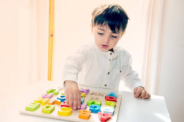 Adorable little child playing with colorful wooden letters stock photo