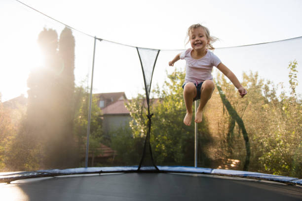adorabile bambina che gioca all'aperto - trampolino foto e immagini stock
