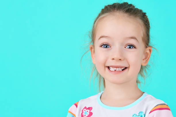 adorable little girl smiling and showing off her first lost milk tooth. cute preschooler portrait after dropping her front baby tooth. - lost first imagens e fotografias de stock