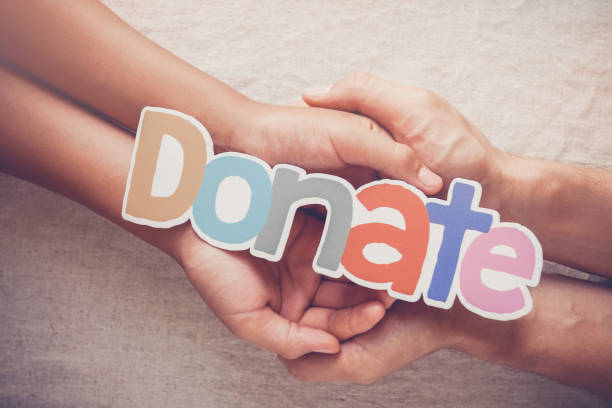 Adult and child hands holding word DONATE, donation and charity concept Adult and child hands holding word DONATE, donation and charity concept blood donation stock pictures, royalty-free photos & images