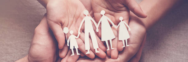 adult and children hands holding paper family cutout, family home, adoption, foster care, homeless support, family mental health, autism support, domestic violence concept - foster kids imagens e fotografias de stock