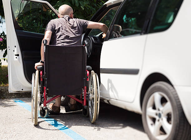 adult driver in wheelchair getting into the car stock photo
