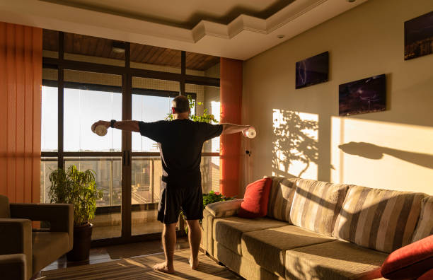 Adult man doing physical exercise at home stock photo
