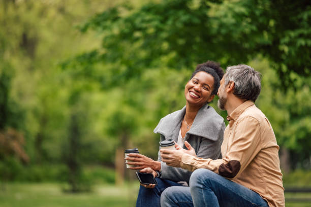 Adult man talking to his wife about his day, in the park. stock photo