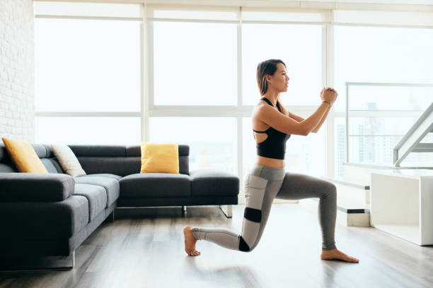 volwassen vrouw training benen doen omgekeerde longen oefening - training stockfoto's en -beelden
