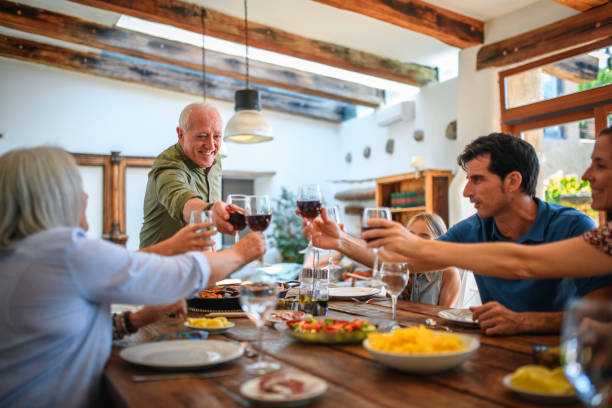 Adults Toasting with Wine and Children with Water at Lunch stock photo
