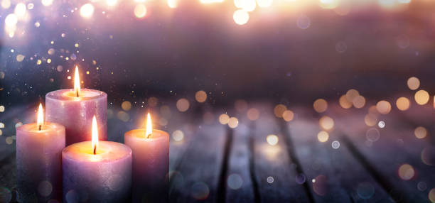 advent - vier lila kerzen mit verschwommenen lichtern - advent stock-fotos und bilder