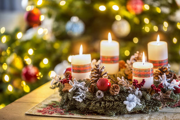 adventskranz mit vier weißen brennenden kerzen weihnachtsball und dekorationen auf holzhintergrund mit festlicher atmosphäre - adventskranz stock-fotos und bilder