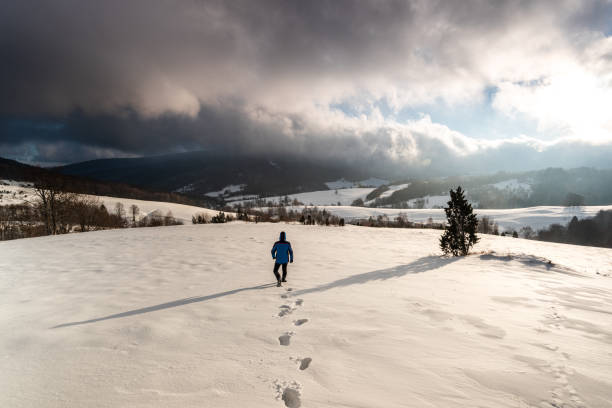 Adventure Man Walk in Deep Snow in Mountains at Winter Season at Sunrise Adventure Man Walk in Deep Snow in Mountains at Winter Season at Sunrise. bieszczady mountains stock pictures, royalty-free photos & images