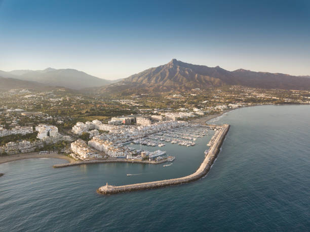 Aerial drone perspective of beautiful sunset over luxury Puerto Banus Bay in Marbella Aerial drone perspective of beautiful sunset over luxury Puerto Banus Bay in Marbella, Costa del Sol. Expensive lifestyle, luxury yachts. La concha mountain in background. Nueva Andalucía area marbella stock pictures, royalty-free photos & images