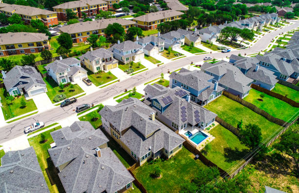 Aerial drone view above suburb rooftops in long line of new homes Aerial drone view looking down on new development and new neighborhood- Aerial drone view above suburb rooftops in long line of new homes istock images stock pictures, royalty-free photos & images
