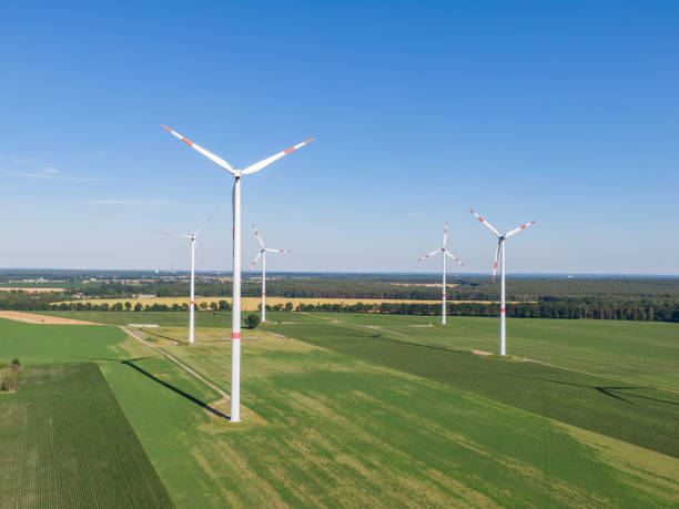 vue aérienne de drone de cinq turbines éoliennes, partie d'un parc éolien, sur un champ vert dans l'allemagne orientale près de la ville de cottbus, brandebourg. les éoliennes font partie de la stratégie de transition énergétique. - transition énergétique photos et images de collection