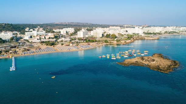 Aerial Fig tree bay, Protaras, Cyprus Aerial bird's eye view of Fig tree bay in Protaras, Paralimni, Famagusta, Cyprus. The famous tourist attraction family golden sandy beach with boats, sunbeds, restaurants, water sports, people swimming in sea on summer holidays, from above. famagusta stock pictures, royalty-free photos & images