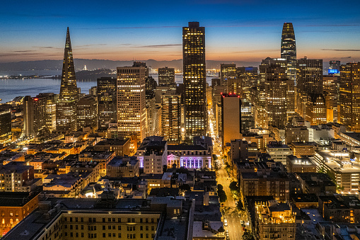 Aerial view as the sun comes up looking towards the Bay from Nob Hill. Iconic buildings fill the horizon.