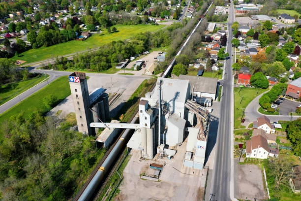 Aerial of a train passing animal feed operation in Woodstock, Canada An aerial of a train passing animal feed operation in Woodstock, Canada. Opened in 1928 and produces feed for animals woodstock ontario stock pictures, royalty-free photos & images