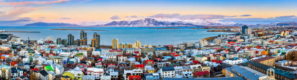 Aerial panorama of downtown Reykjavik Aerial panorama of downtown Reykjavik at sunset with colorful houses and snowy mountains in the background reykjavik stock pictures, royalty-free photos & images
