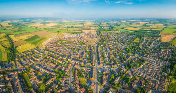 Aerial panorama over summer suburbs streets family homes green fields stock photo