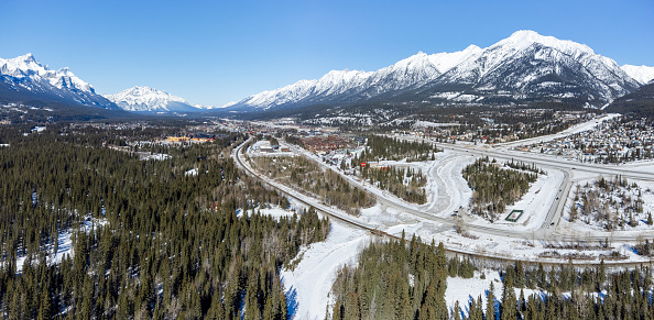 Aerial panorama view of Town of Canmore and Canadian Rockies mountain range in winter. Grotto mountain. Alberta, Canada.