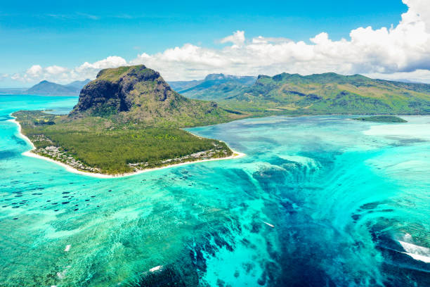 Aerial panoramic view of Mauritius island - Detail of Le Morne Brabant mountain with underwater waterfall perspective optic illusion - Wanderlust and travel concept with nature wonders on vivid filter stock photo