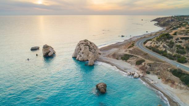 Aerial Petra tou Romiou, Paphos, Cyprus Aerial Bird's eye view of Petra tou Romiou, aka Aphrodite's rock a famous tourist travel destination landmark in Paphos, Cyprus. The sea bay of goddess Afroditi birthplace at sunset from above. cyprus island stock pictures, royalty-free photos & images