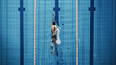 istock Aerial Top View Male Swimmer Swimming in Swimming Pool. Professional Athlete Training for the Championship, using Front Crawl, Freestyle Technique. Top View Shot 1332857796