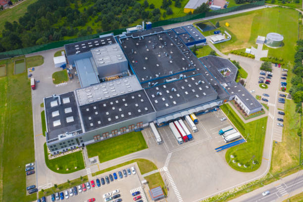 aerial top view van industriële opslag bouwgebied met zonnepanelen op het dak en vele vrachtwagens lossen merchandise. - zonnepanelen warehouse stockfoto's en -beelden