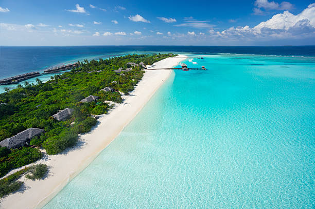 aerial tropical island resort and lagoon aerial view of wide turquoise lagoon in the indian ocean and island with long sandy beach atoll stock pictures, royalty-free photos & images