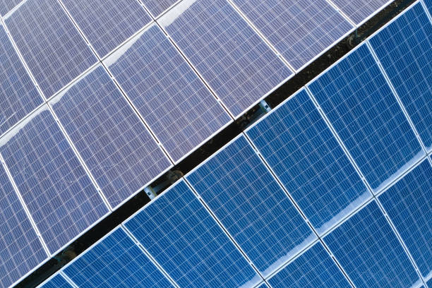 Aerial view building roof with rows of blue solar photovoltaic panels for producing clean ecological electric energy. Renewable electricity with zero emission concept stock photo